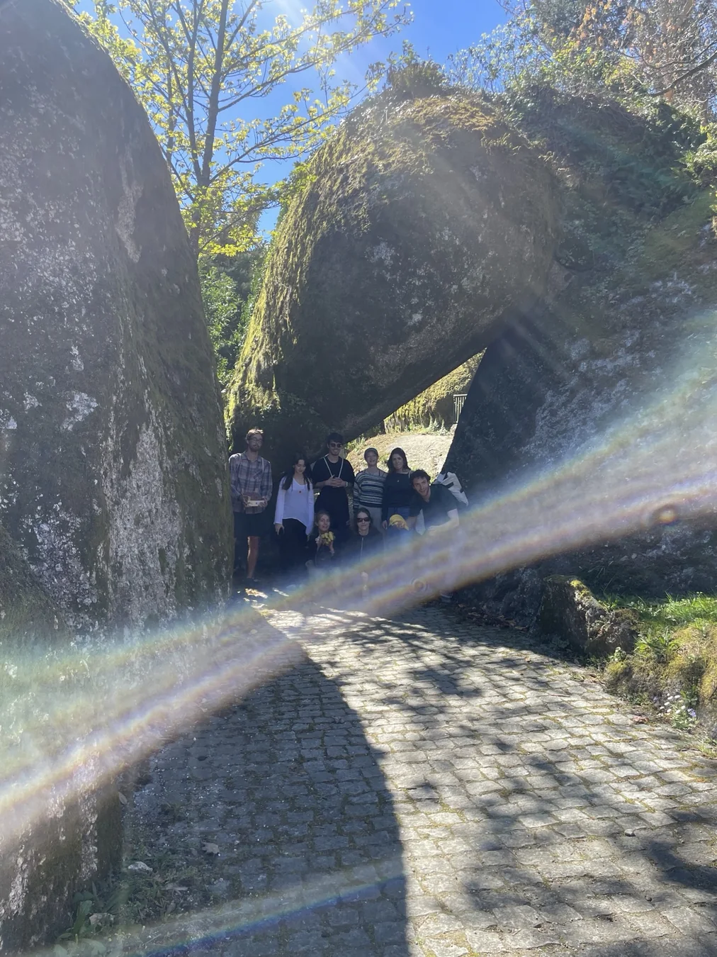 Grupo de voluntários numa passagem sob uma ponte de pedra